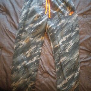 Guys Nike camo pants with orange tie and Nike synbol.